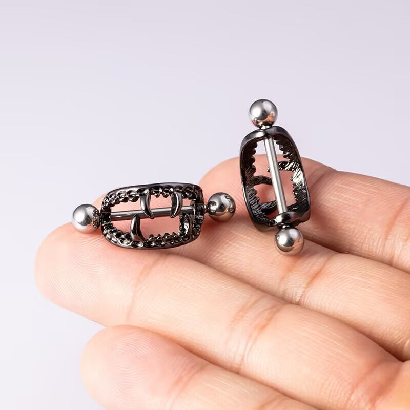 Black gothic vampire fang nipple shield held in hand for size reference.