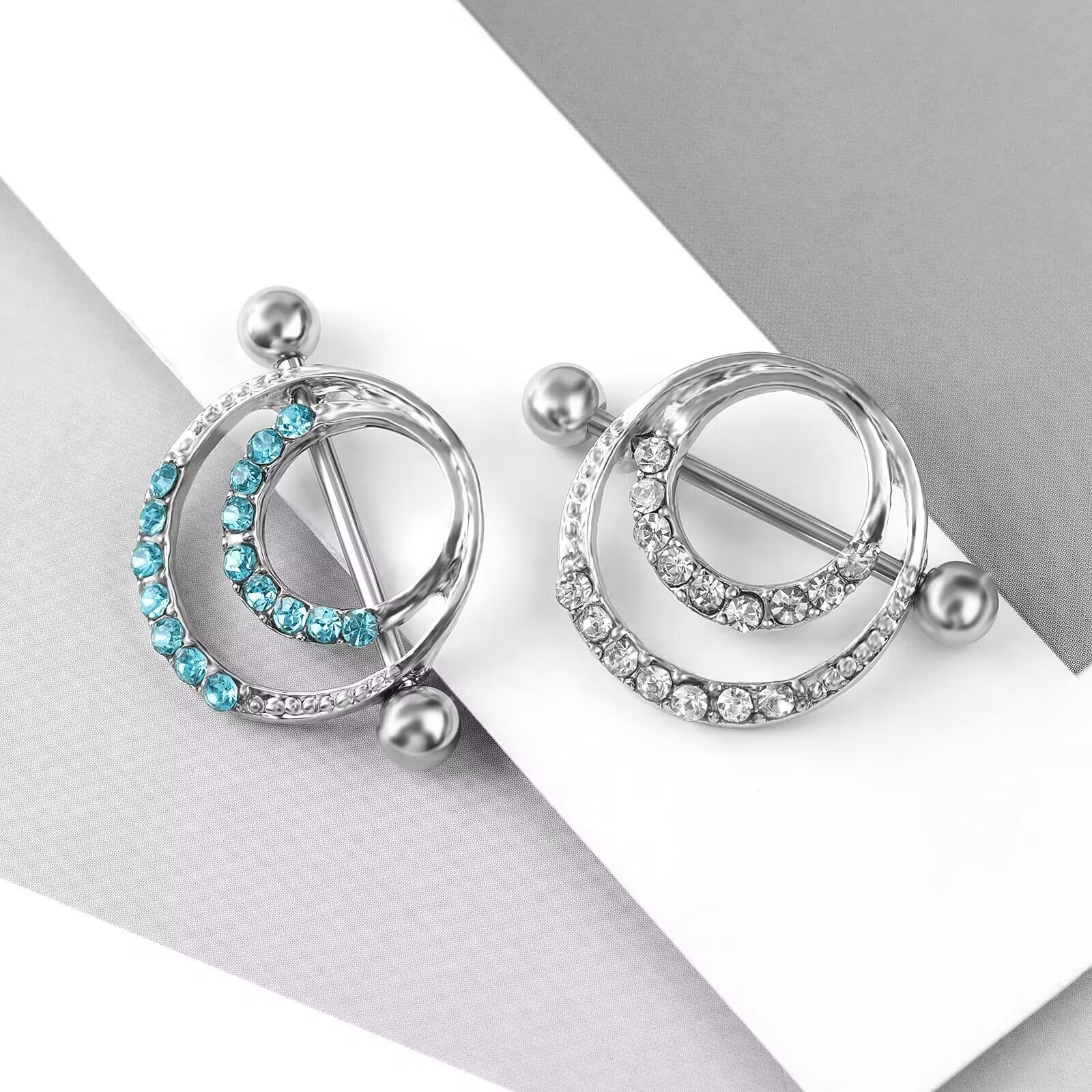 Comparison view of blue and clear crystal nipple shields on a stylish background.