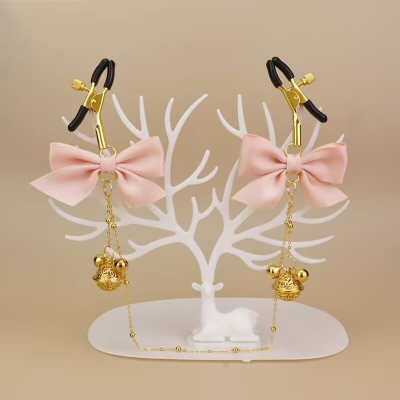 Pink bow sensory clamps displayed on an aesthetic white tree stand.