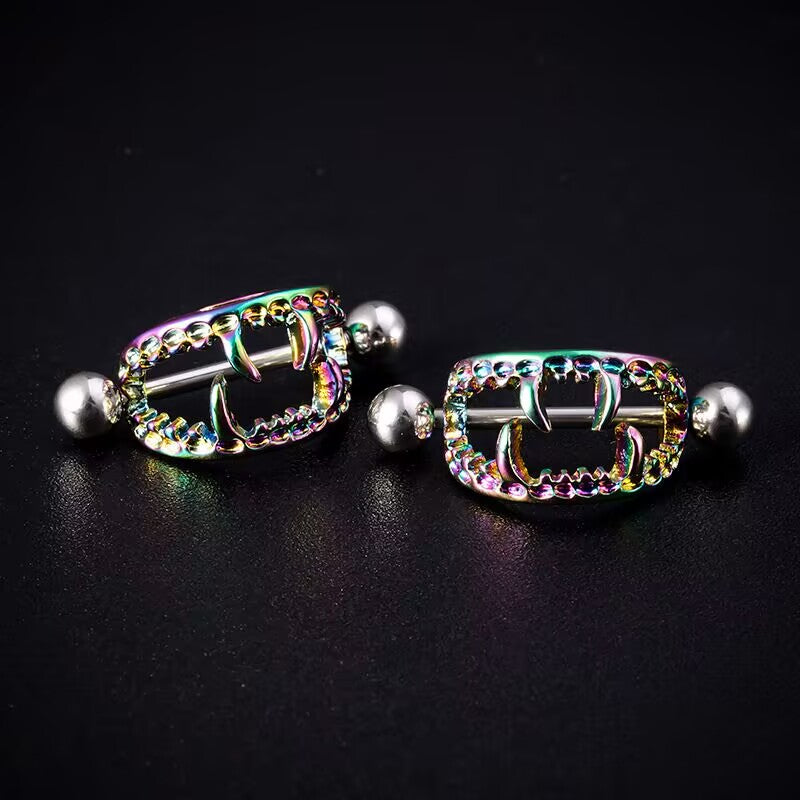 Two iridescent rainbow vampire nipple shields on a textured dark background.