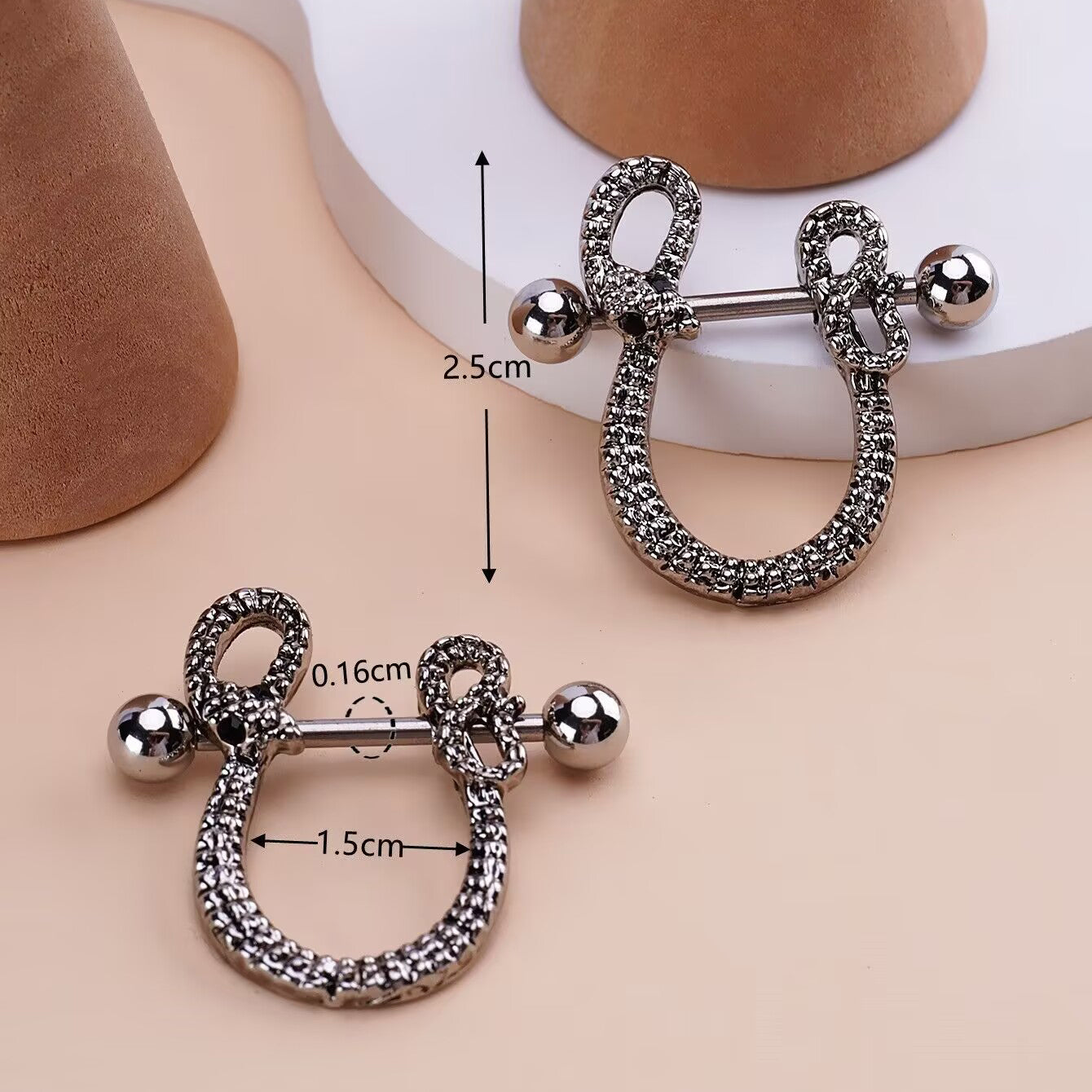 Close-up of snake nipple piercing with 1.5cm width and 2.5cm height measurements