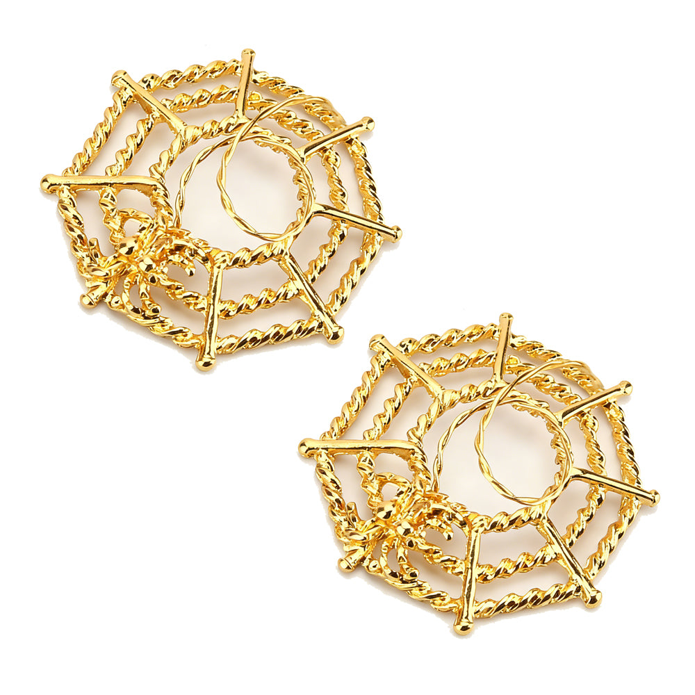 A matching pair of gold-colored spider web nipple shields for body piercing.
