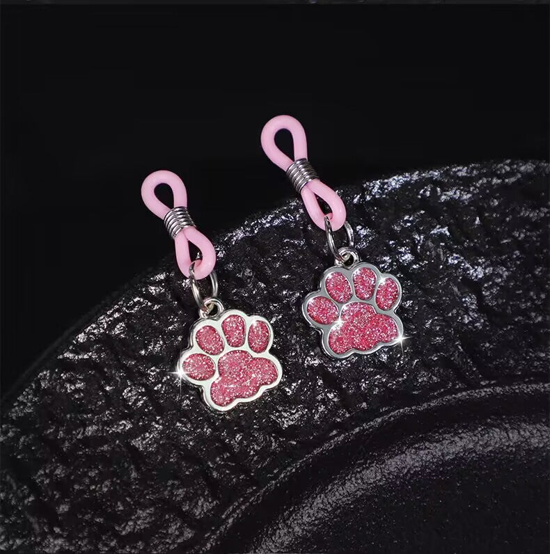 Detailed view of the shimmering pink surface on the paw print body accessory
