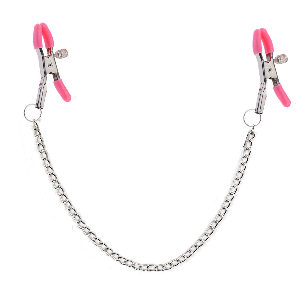 Silver fetish clamps featuring hot pink tips for couples play.