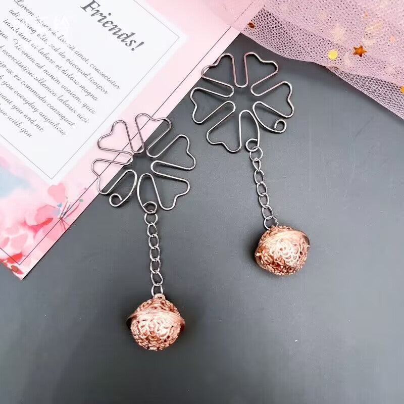 Pair of rose gold bell dangle clips styled with a pink aesthetic card for e-commerce listing.