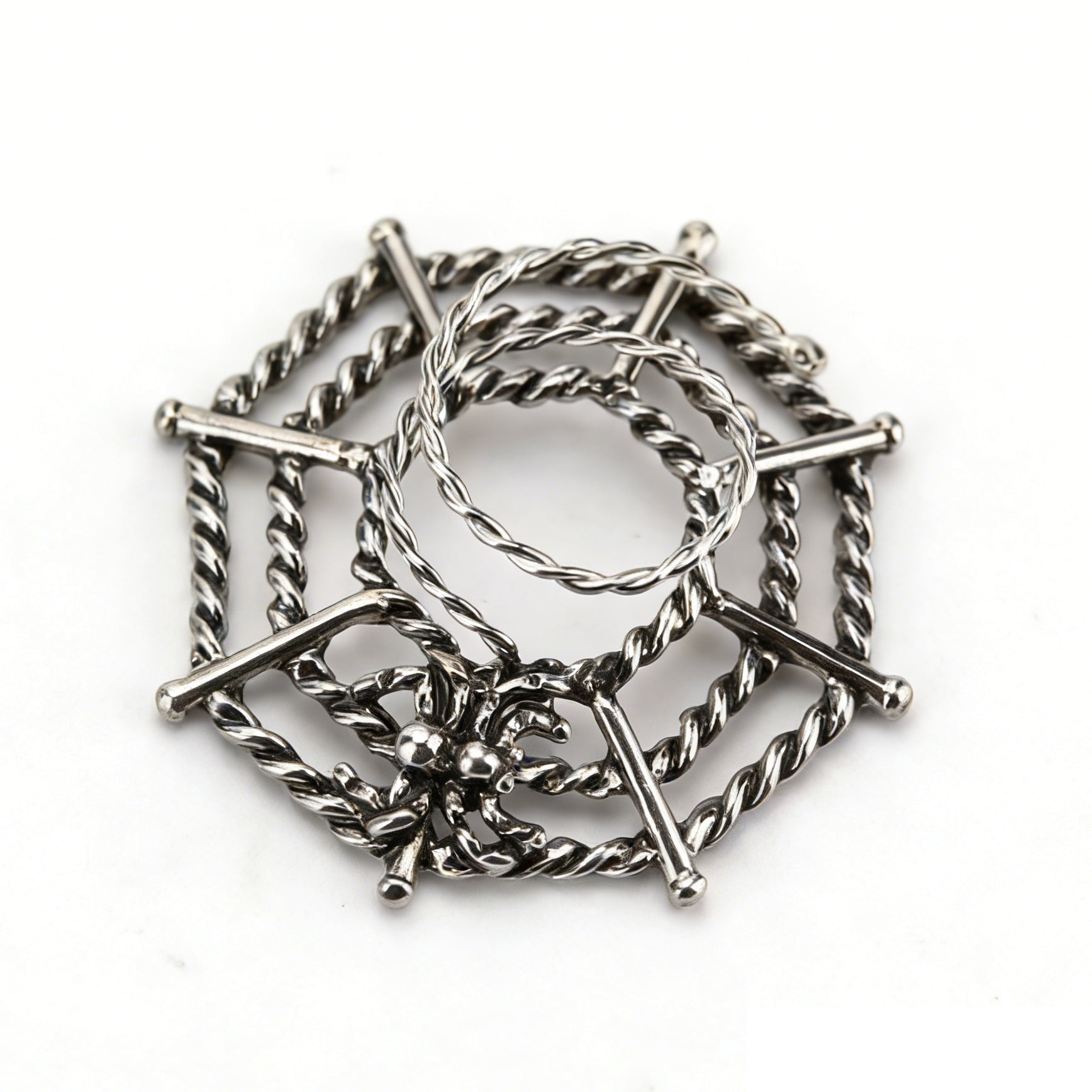 Top down view of silver gothic spider web nipple piercing accessory.