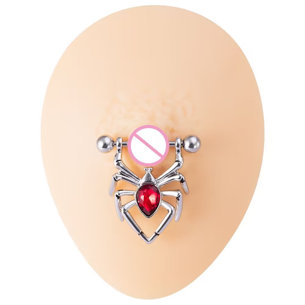 Polished silver spider nipple shield ring with a red gem shown on a nude silicone piercing mold.