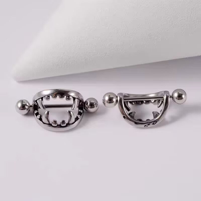 A pair of classic silver vampire teeth nipple barbells displayed together.